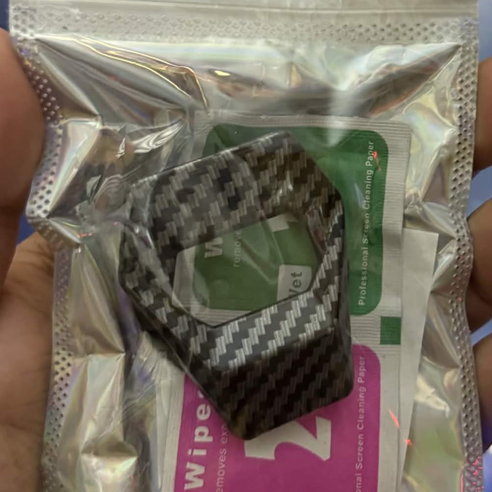 Engine start button cover in carbon fibre, in its packet