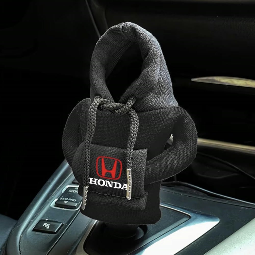 A black knit hoodie fitted over a car's gear lever