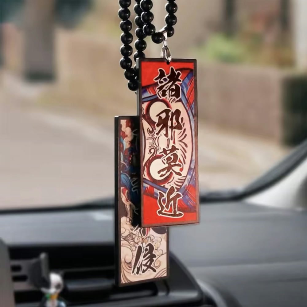 Two wooden JDM charms on a beaded cord, hanging from a car mirror
